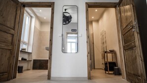 A hallway with wooden doors, a mirror, and a view into a room with a window and a radiator. - Rheinfreunde Bingen das Ferienhaus für Viele (Bingen am Rhein)