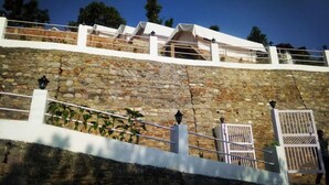 A stone wall with a white railing and a gate.