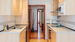 A modern kitchen with wooden cabinets, a central island, and a view to the outside.