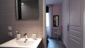 A modern bathroom with a white sink, two towel dispensers, and a mirror above the sink. - La Dolce Vitae (Rodez)
