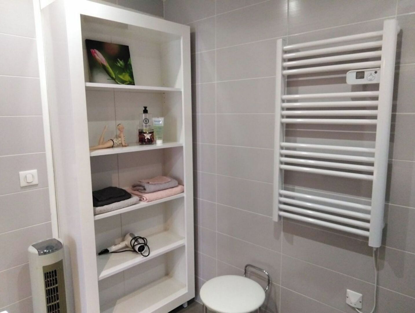 Een badkamer met een wit wastafelmeubel, een handdoekhouder en een toilet.