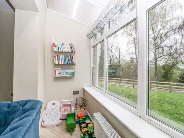 A child's playroom with a large window, a bookshelf, and a toy truck. - Orchard House (Leominster)