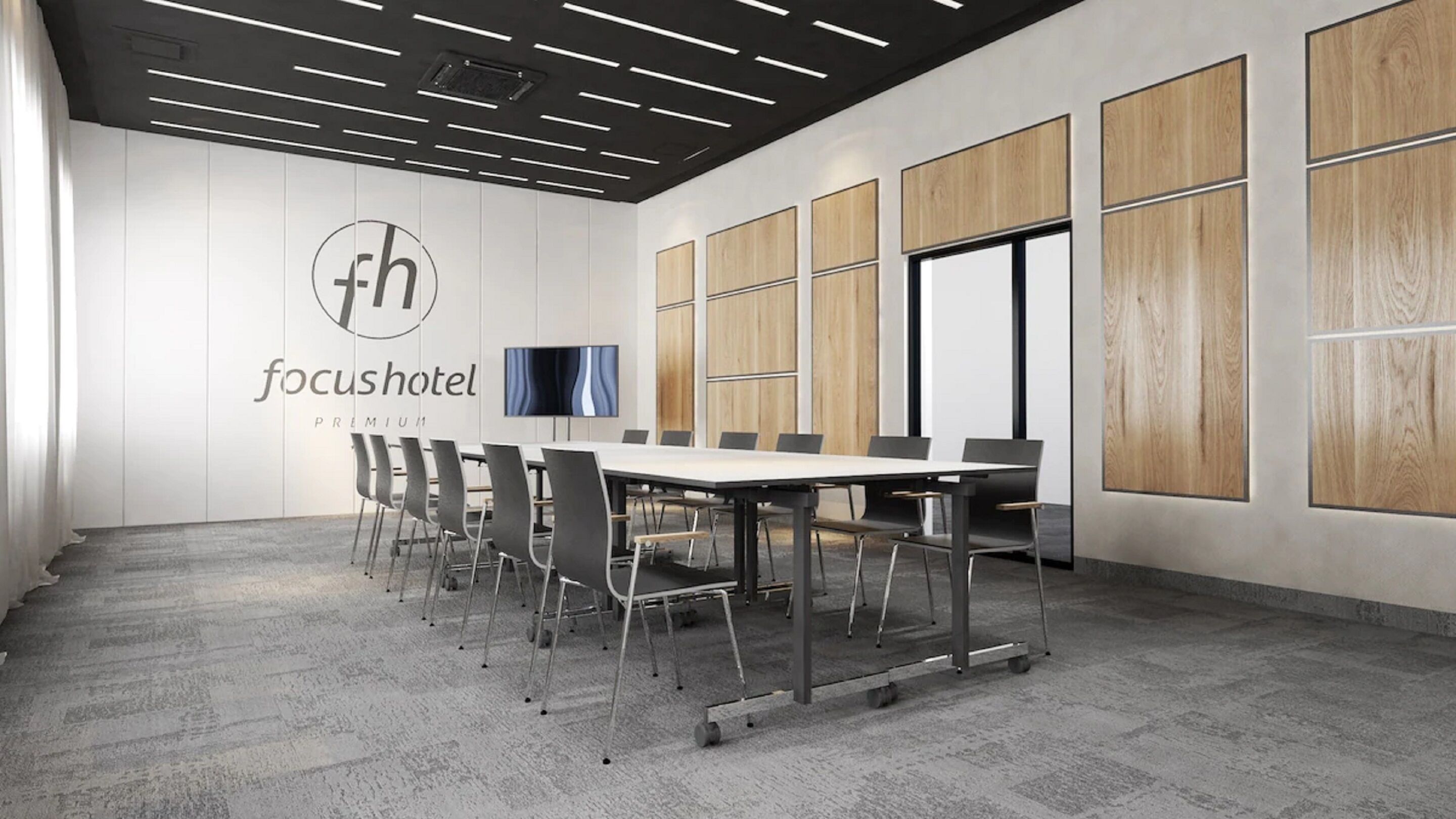 A conference room with a whiteboard, a television, and a logo for 'focushotel'.