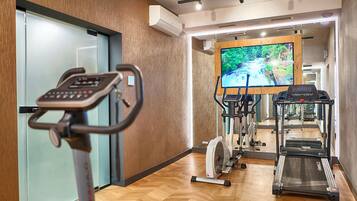 A gym with cardio equipment, a treadmill, and a stationary bike.