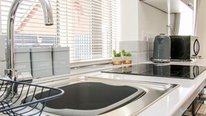 A modern kitchen with a stainless steel sink, a kettle, and a toaster. - Little Oakleigh (Llanymynech)