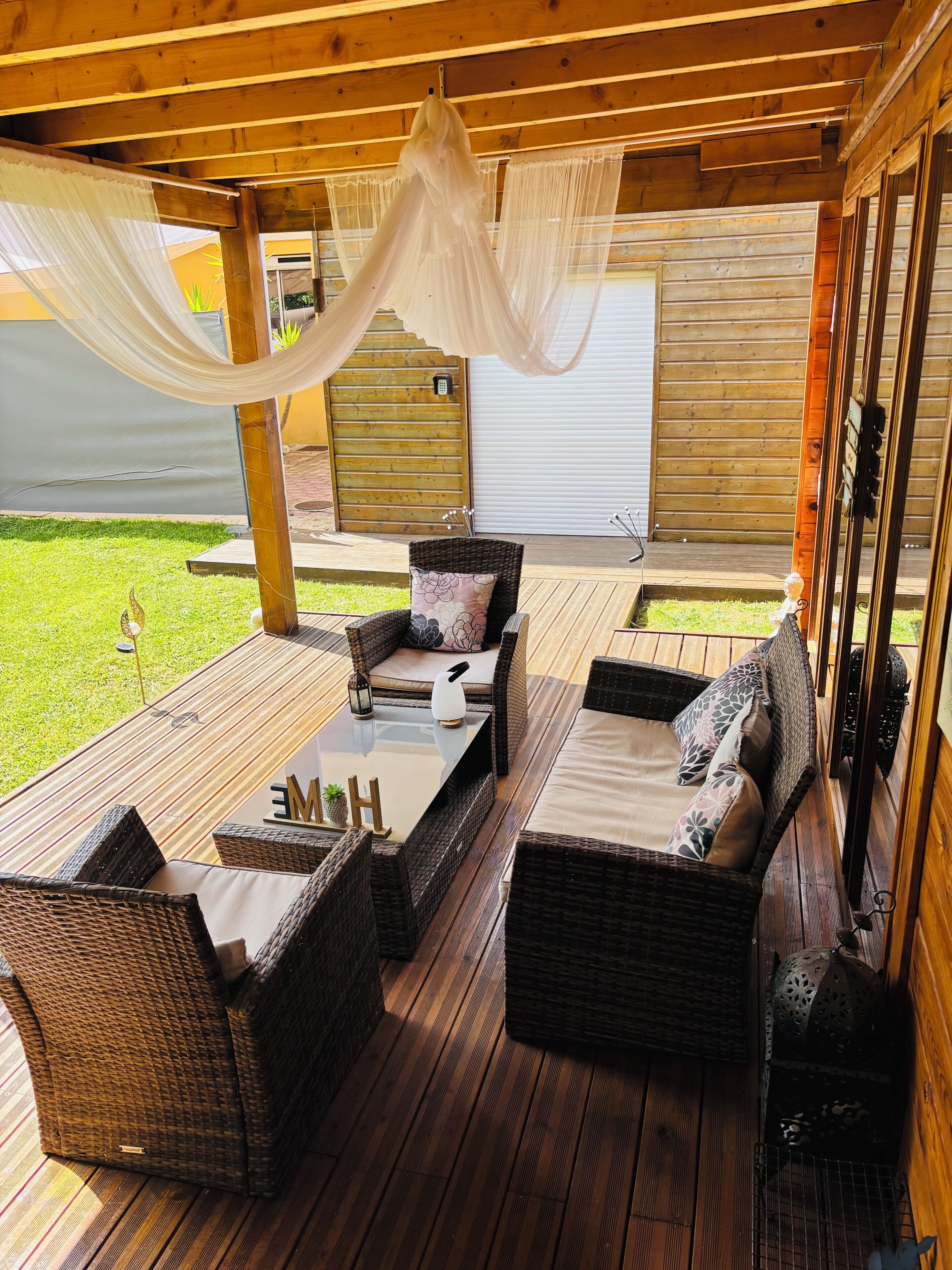 A covered outdoor seating area with wicker furniture and a canopy.