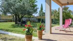 A covered patio area with two large potted plants, a grill, and a pink lounge chair. - Istria Rosa in Pula - Istrien / Istria Rosa in Pula - Appartement für 4-5 Personen (Pula)