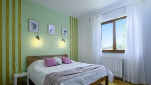 A bedroom with a bed, bedside tables, and a window with curtains. - Istria Rosa in Pula - Istrien / Istria Rosa in Pula - Appartement für 4-5 Personen (Pula)
