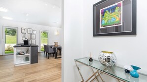 A modern kitchen with a dining area, a glass coffee table, and a framed artwork on the wall. - Charming Villa Audrey with an outdoor pool (Umag)