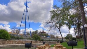 A park with picnic tables, a water body, and a tall blue structure. - Timeless Tranquility Crc 317 2 Bedroom Condo by RedAwning (New Braunfels)