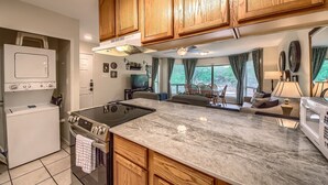 A kitchen with wooden cabinets, a built-in stove, and a large island. - Timeless Tranquility Crc 317 2 Bedroom Condo by RedAwning (New Braunfels)