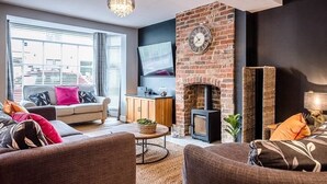 Una sala de estar moderna con chimenea, un sofá, una mesa de centro y una televisión.
