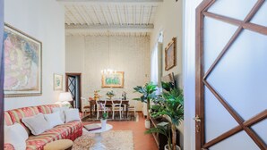 Un salon confortable avec un canapé, une table à manger et une grande fenêtre.