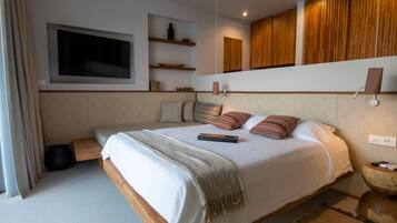 Un dormitorio moderno con una cama grande, mesitas de noche, un televisor montado en la pared y paneles de madera.