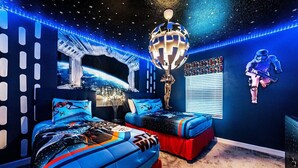 A bedroom with two beds, a globe chandelier, Star Wars posters, and a space-themed wall design. - Last Minute Disney Getaway! Townhouse with Private Pool. Book Now! #49423 (Orlando)