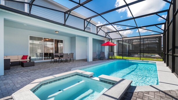 A swimming pool with a hot tub, outdoor seating, and a covered patio area. - Last Minute Disney! Private Pool, Hot Tub & Themed Bedrooms. Book Now! #49467 (Orlando)