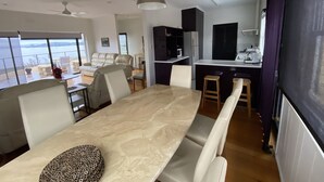 Un espacio habitable moderno con comedor, cocina y balcón con vistas.