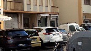 Un edificio de varios pisos con balcones y un local comercial en la planta baja.