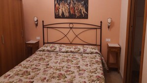 Un dormitorio con una cama, un cuadro en la pared y dos mesitas de noche.