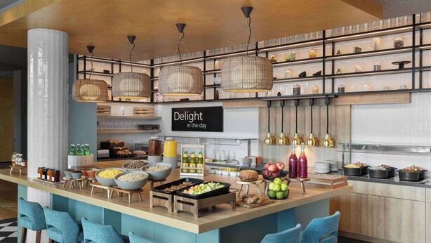 Una cucina moderna con angolo bar, con un cartello che recita “Goditi la giornata” e diversi cibi e bevande esposti.