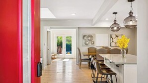 A modern kitchen with a central island, pendant lighting, and a view to the outdoors. - The Elm House: Private Pool, Hot Tub, Napa Getaway (Napa)