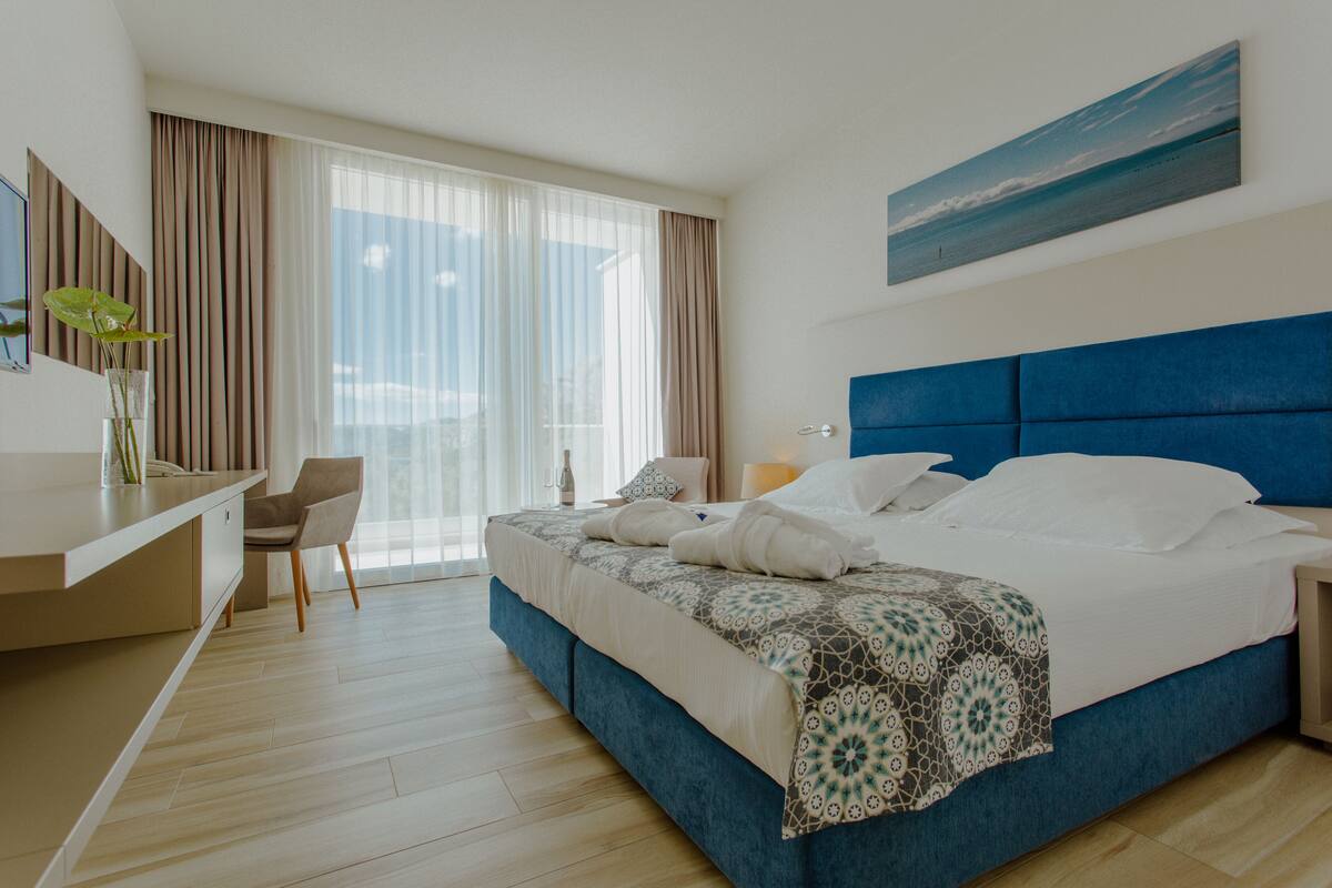 Een moderne hotelkamer met een groot bed, een bureau en een stoel.