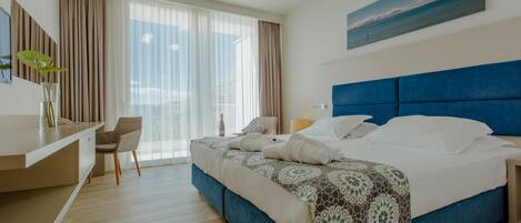 Una habitación de hotel moderna con una cama grande, un escritorio y una silla.