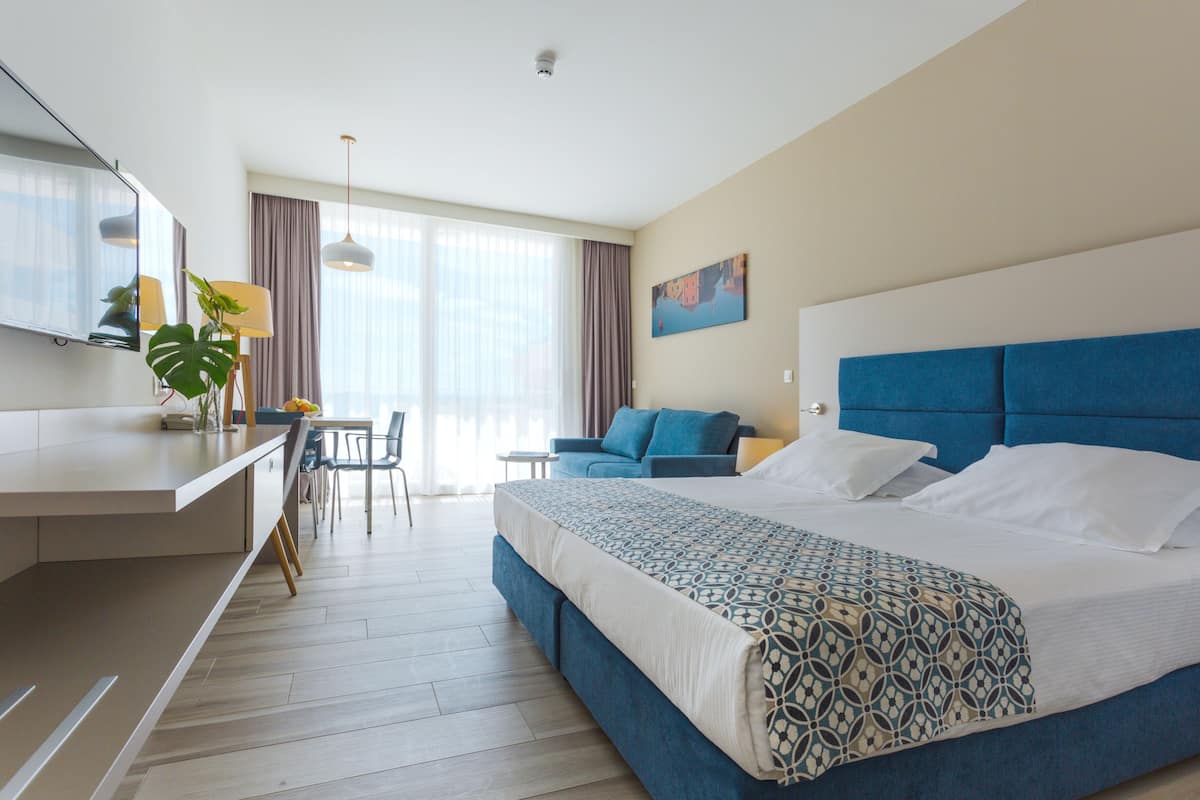 Een moderne hotelkamer met een groot bed, een bureau en een zithoek.