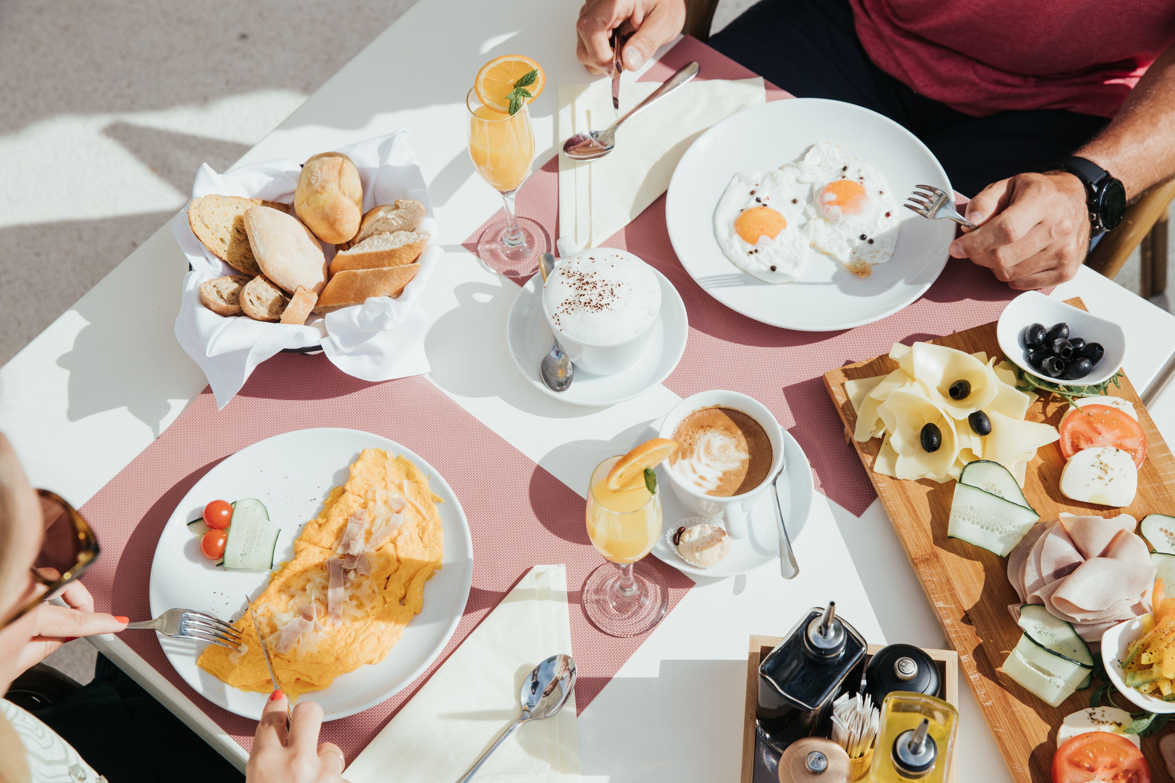A breakfast setting with various food items and drinks on a table.