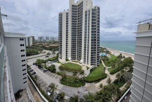 A high-rise hotel with a central courtyard, a pool, and a beach view. - Areia Azul Aparts Miami (Sunny Isles Beach)