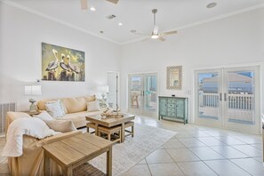A spacious living room with a sofa, coffee table, and a painting of pelicans.