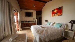 Un dormitorio con una cama, mesitas de noche, un televisor y un cuadro de un atardecer.