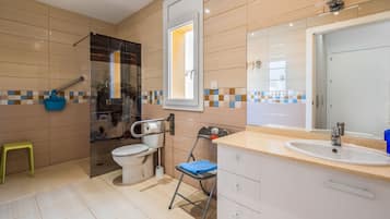 Un baño moderno con inodoro, lavabo y ducha.