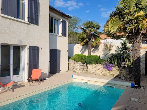 A swimming pool with a stone wall and palm trees. - VILLA 3 STARS 10 PEOPLE SWIMMING POOL SHOPS 1.2 km BEACHES (Saint-Georges-de-Didonne)