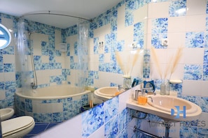 A bathroom with a bathtub, two sinks, and a toilet. - Marina Views T2 Apartment (Albufeira)