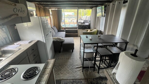 Une petite cuisine équipée comprenant une cuisinière, un réfrigérateur et une petite table à manger avec des chaises.