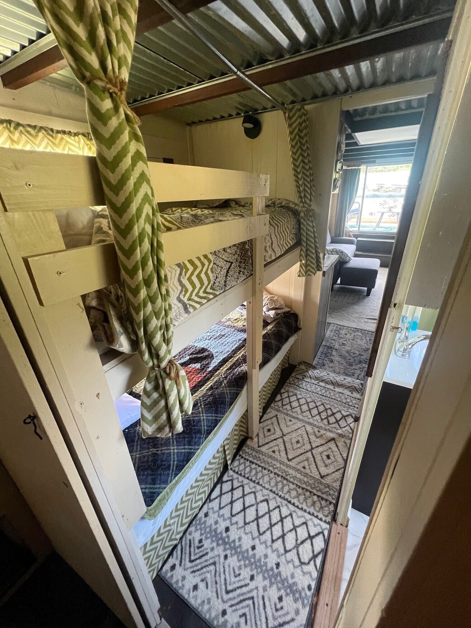 Habitación con literas, ropa de cama estampada y vistas a un espacio exterior.