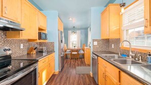 Una cocina compacta con armarios de madera, un microondas, una estufa y un lavabo.