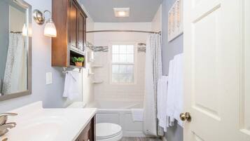 Bathtub, hair dryer, towels, shampoo