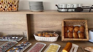 A breakfast buffet with various food items and utensils.