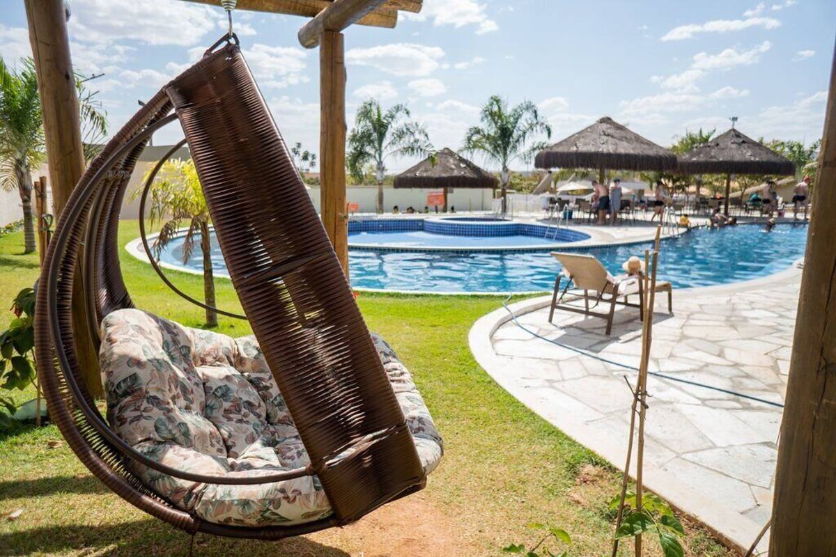 Ein Poolbereich mit Hängesessel, Liegestühlen und einem Pool.