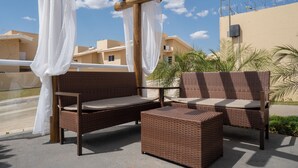 A wicker outdoor seating area with a pergola and white curtains. - Jardins da Lagoa - Casas Completas (Caldas Novas)