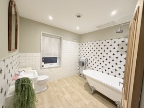 A bathroom with a toilet, sink, bathtub, and shower.