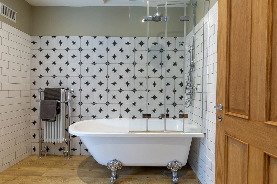 A bathroom with a freestanding bathtub, a towel rack with towels, and a showerhead.