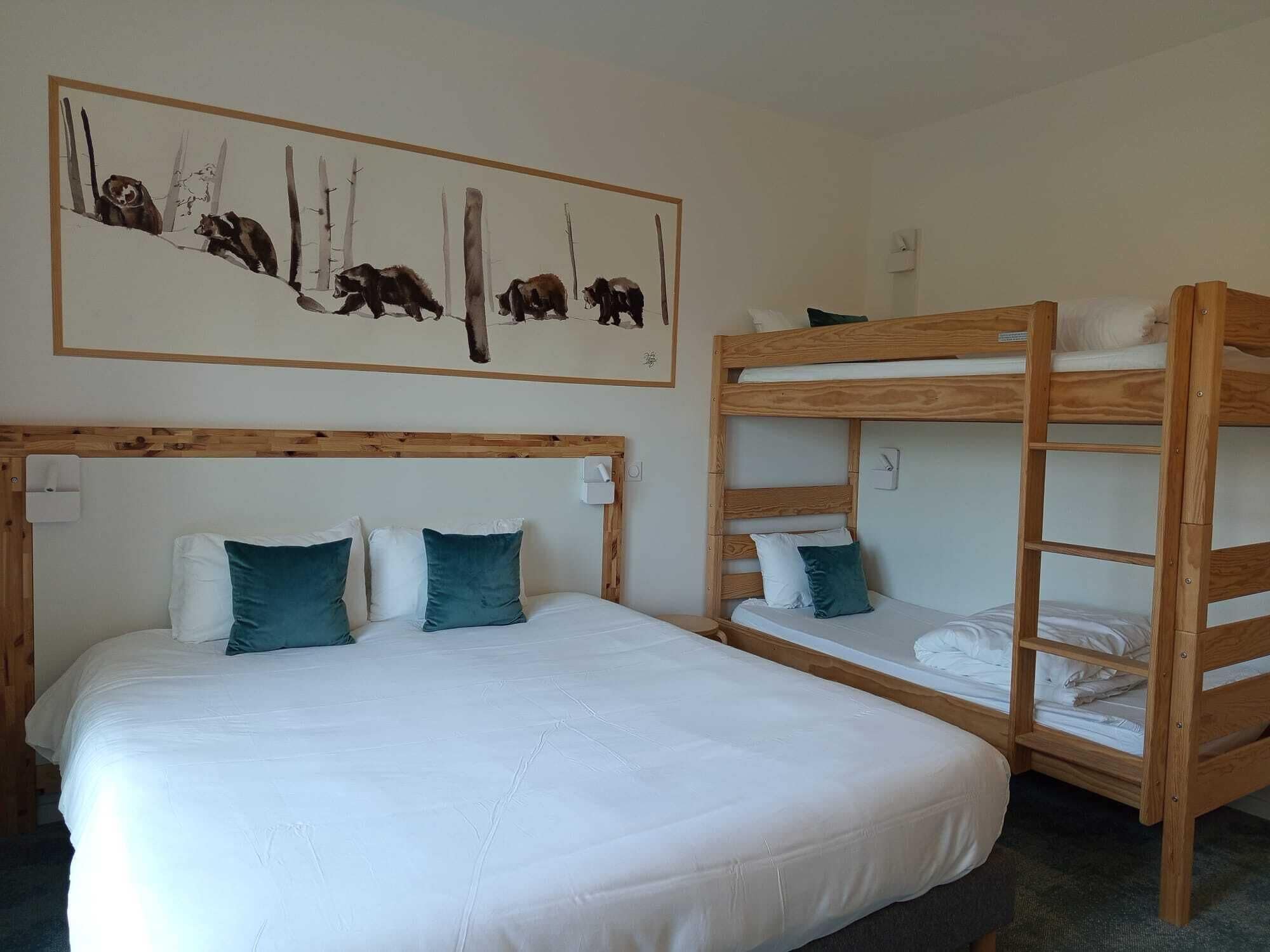Una habitación con una cama grande, dos literas y un cuadro de osos en la pared.