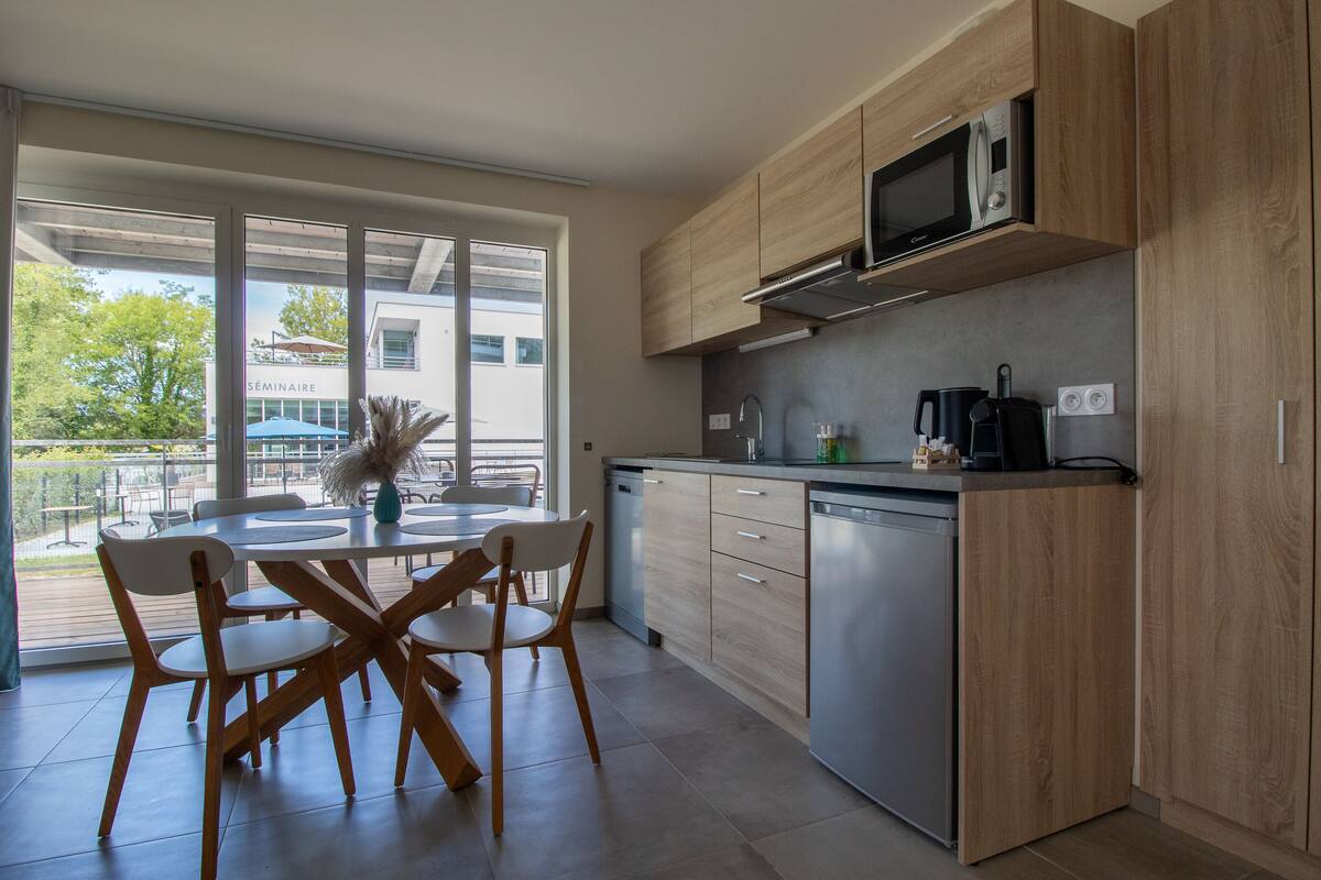 A modern kitchen with wooden cabinets, a stainless steel dishwasher, and a microwave.