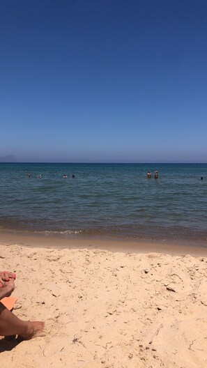 A sandy beach with a clear blue sky and calm sea. - "Turtles" Vacation Home, 7 minutes from the ocean (Alcamo)