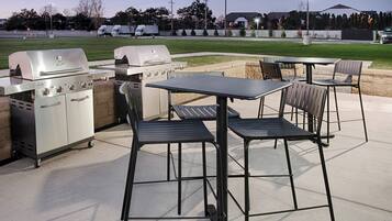 An outdoor patio with a grill and seating area.