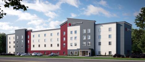 A multi-story hotel with a modern design, featuring a mix of red and grey facades, and a prominent "Candlewood Suites" sign.
