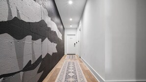 A hallway with a patterned rug, a door labeled '203', and a textured wall. - 1/2 Block from King Street, Elegant Old Town Oasis ~ King Bed♛ ~ Free Parking (Alexandria)